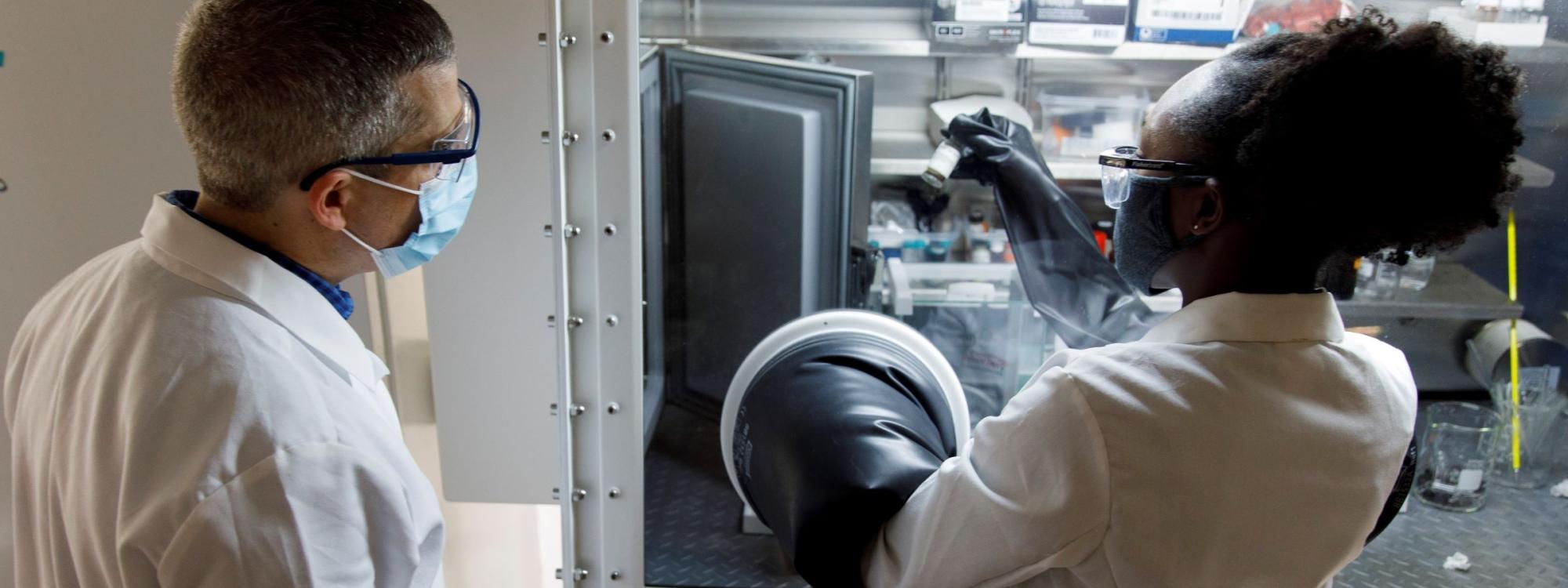 Professor and student working on experiment under fume hood